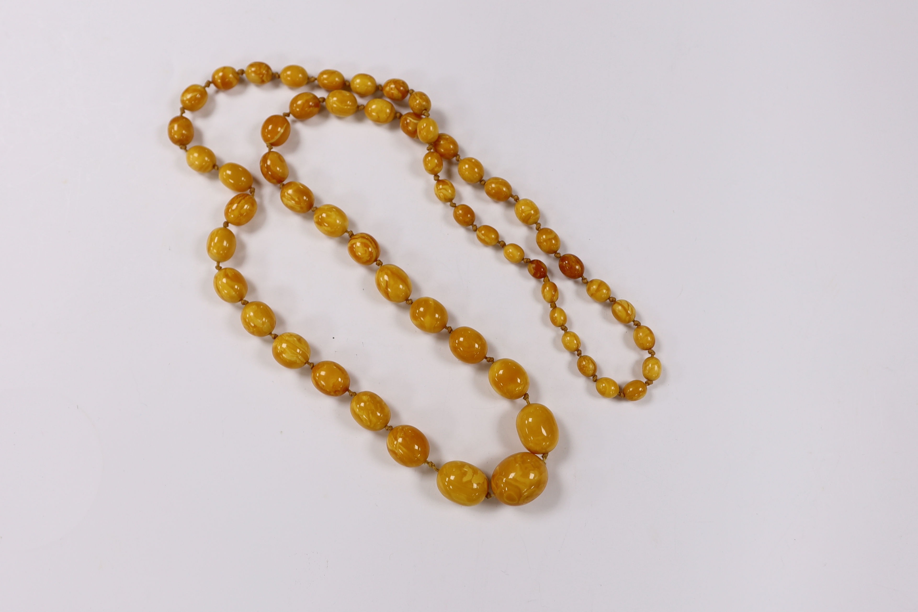A single strand graduated oval amber bead necklace, 108cm, gross weight 93 grams.